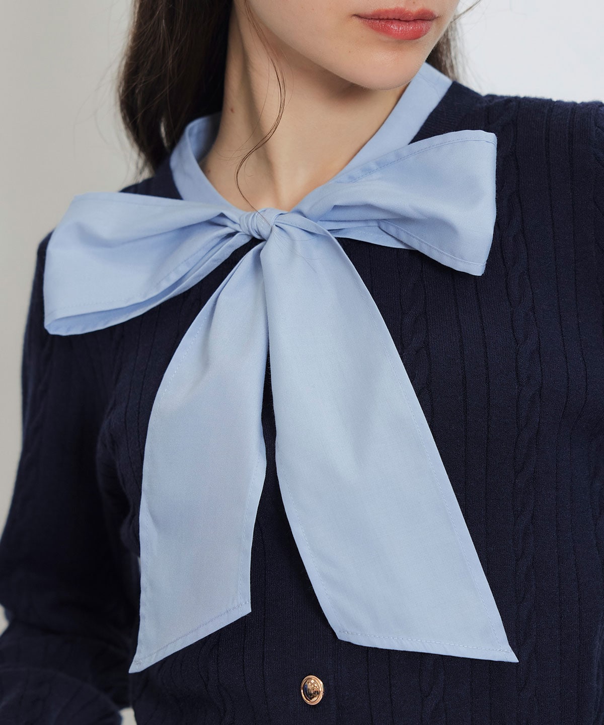 エンブレムボタンケーブルリボンタイニットトップス